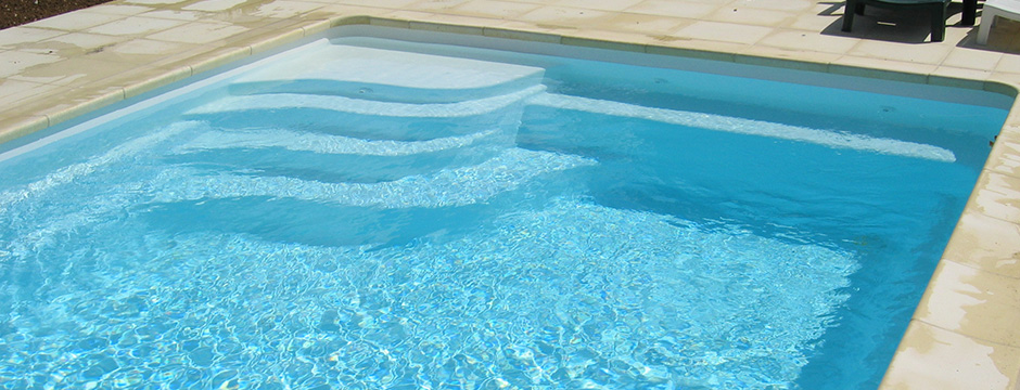 Piscine enterrée avec escalier d'angle et margelles grises