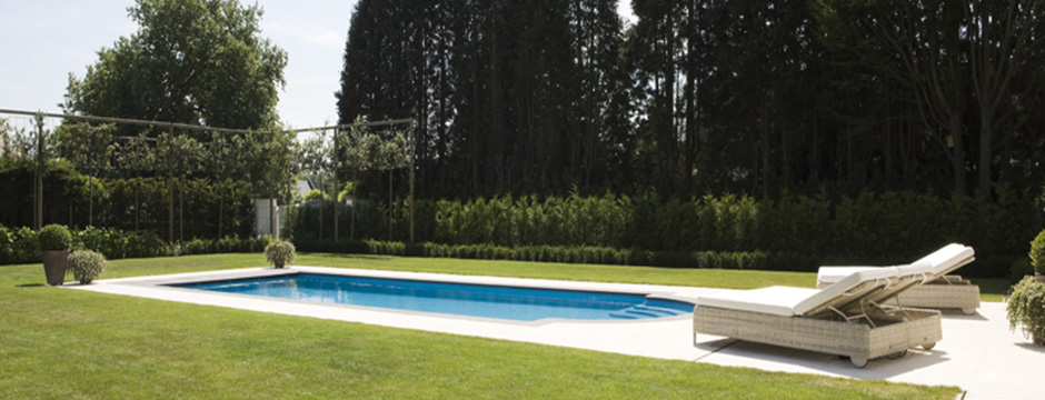 Piscine enterrée rectangulaire avec terrasse bois et brise-vue