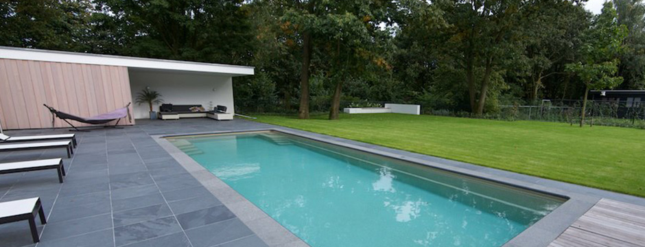 Bassin enterré moderne avec margelles claires et pelouse