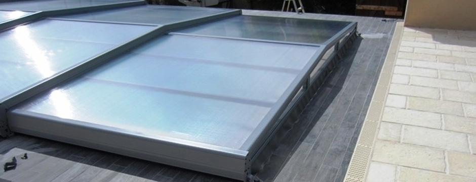 Abri de piscine bas en polycarbonate sur une terrasse